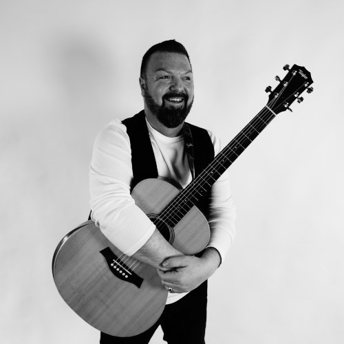 Marc Gensior mit Gitarre in schwarz weiß